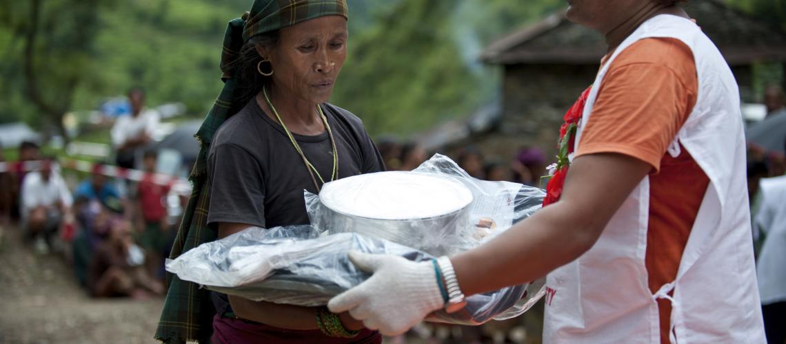 Red Cross worker handing package to woman