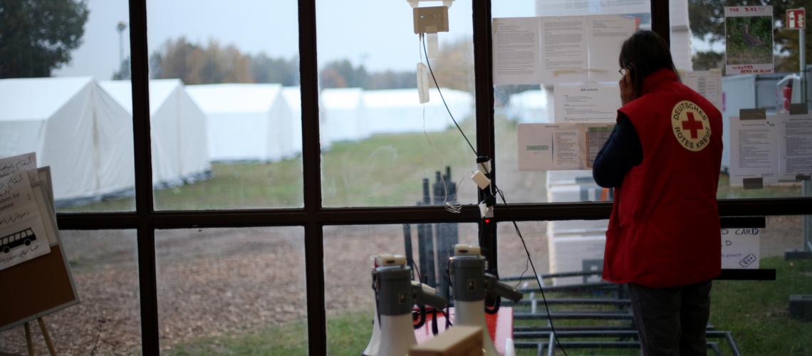 Humanitarian aid worker looking out to white tents