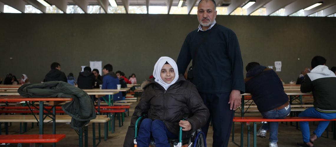 Woman in a wheelchair with man behind her