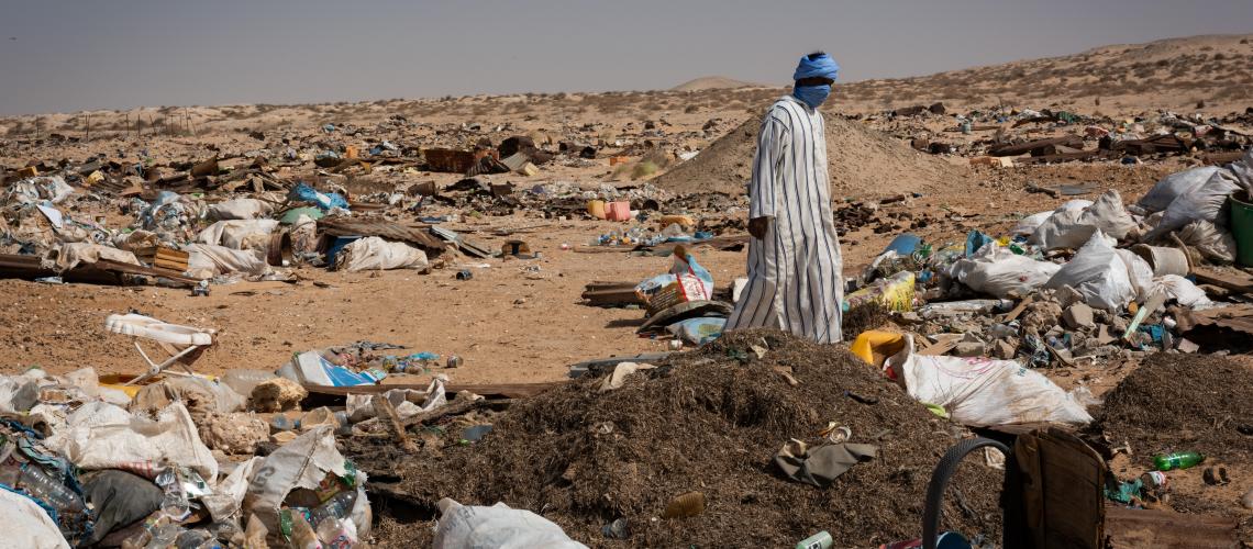 Man walking through littered desert