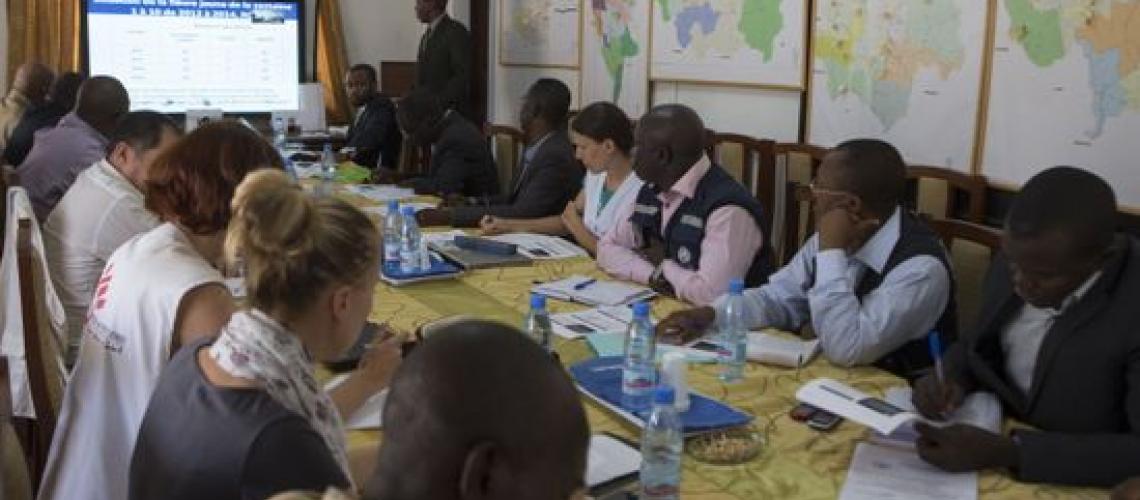 People at meeting table with presentation on 