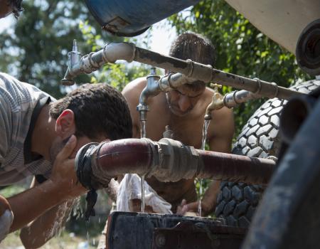 Men washing themselves by a water source