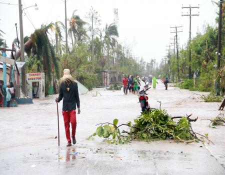 Man walking down street beside tree branch