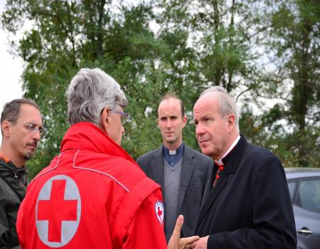 Men huddled with Red Cross worker