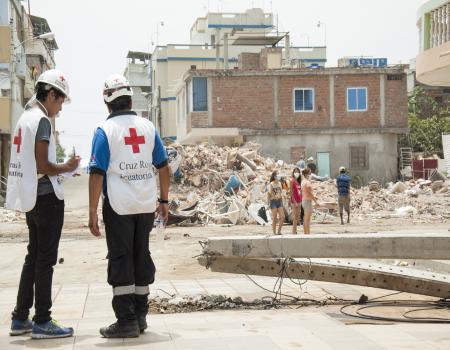 Two Red Cross workers standing on a street