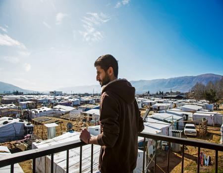 Man on roof of building overlooking town