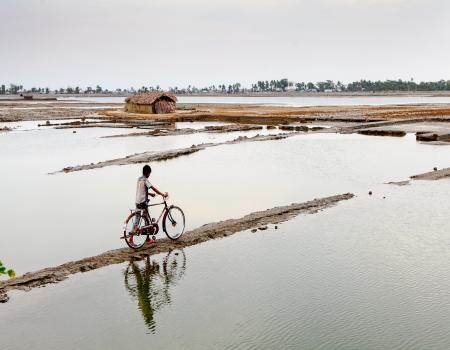 Man walking with bicycle in a flooded area