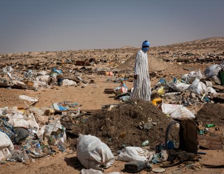 Man walking through littered desert