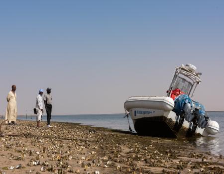 Men beside a boat on the beach