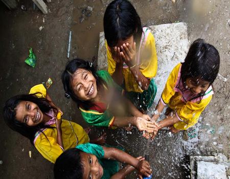 Young girls playing with falling water