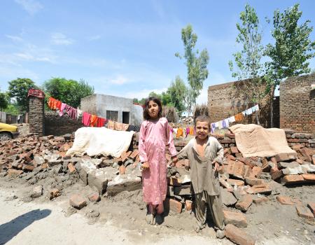 Children standing in front of a settlement