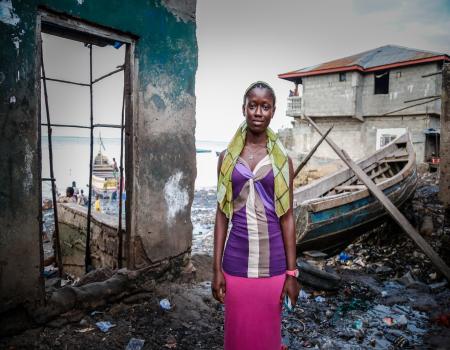 Young woman standing in a flood damaged coastal area